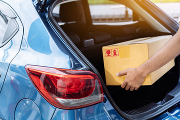 Delivery man carrying cardboard box for sending deliver to customer by transportation system hatchback car, Business of male transport sell part or product service parcel for convenience of customer