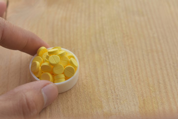 Yellow pills on wood table