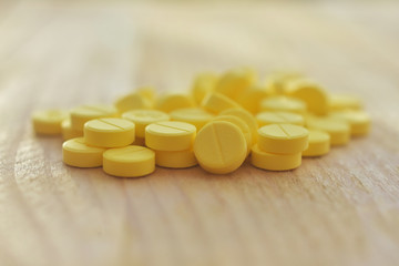 Yellow pills on wood table