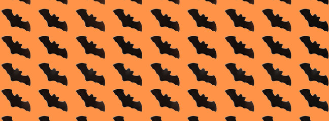 Black Paper Bats on orange background. Halloween concept. Banner for web design. Flat lay, top view, copy space, mockup