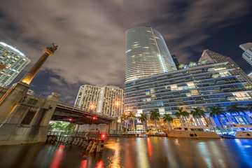 Brickell draw bridge Downtown Miami over river. Night long exposure photo blurry clouds in motion