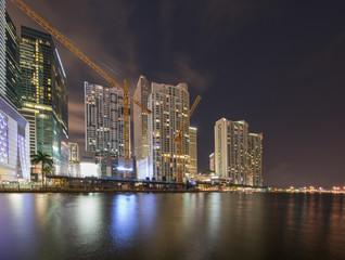 Fototapeta na wymiar Night photography Miami River with view of Downtown lit at night. Long exposure smooth blurry water