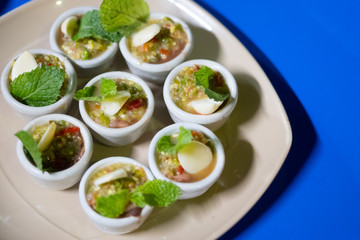 Fresh blood cockle or blood clam in spicy seafood sauce served in mini cup.