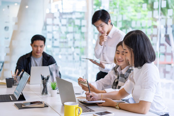 Group of asian diverse university students concentrated on study or working together with laptop at a university. indoor