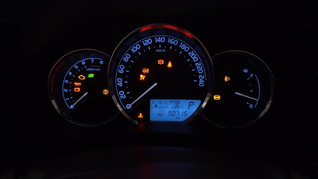 Modern car dashboard with various status symbols in night time