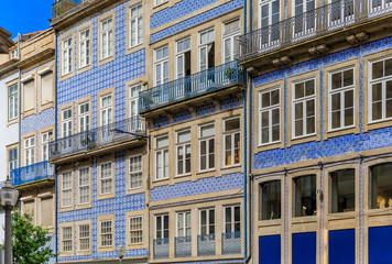 Facades of traditional houses decorated with ornate Portuguese azulejo tiles in Porto, Portugal