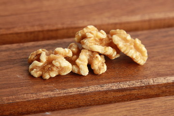 Peeled walnuts on wooden background
