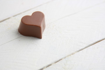 Chocolate bonbon with heart shape on white background..