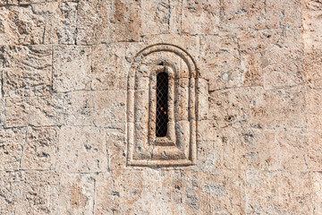 Window in the wall of an ancient Albanian temple in the village of Kish, the city of Sheki