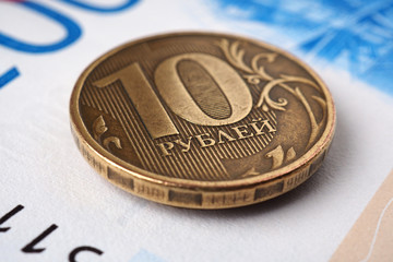 Russian ten-ruble coins are on a Russian banknote of two thousand rubles. Close-up