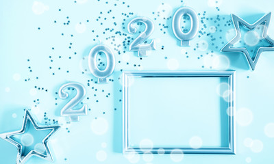 Happy New Year 2020. Christmas clock and star on pastel blue background. Flat lay, top view, copy space