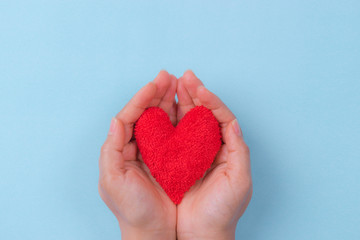 Obraz premium Woman hand holding a red heart. World Heart Day concept.