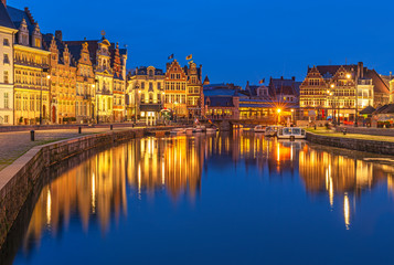 Cityscape of Ghent (Gent) city during the blue hour with its historic flemish guild houses having a reflection in the Leie river, East Flanders, Belgium.