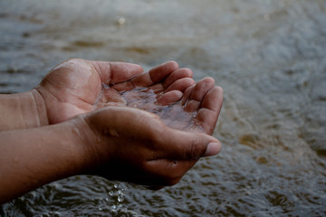 Water in male hand with surface river.World water or Environment day. Save water concept,