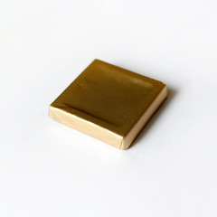Square chocolate candy wrapped in blue foil isolated on white surface. Object for greeting card, poster or invitation. Backdrop or background