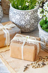 Beautifully wrapped gift for the first communion, rosary and floral decorations.