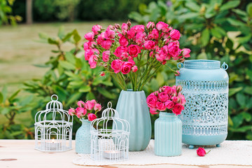 Floral table arrangement with pink roses and romantic lanterns. Garden party. © agneskantaruk