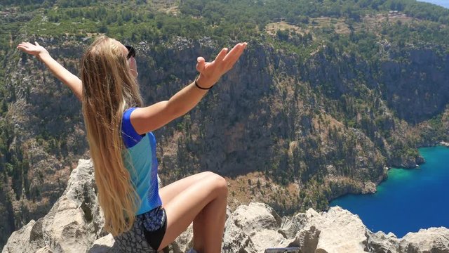 Young woman enjoying freedom and taking sun bath with beatiful viewn of Butterfly Valley on background in Turkey