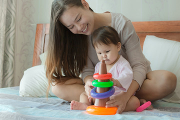 Mom teaching her baby with toys at home.