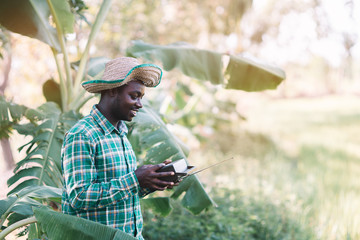 African farmer man holding vintage radio at the farm..