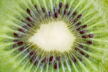 Corte transversal de un kiwi maduro con semillas en su interior.