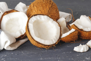 Pile of broken coconuts on ripped grey background