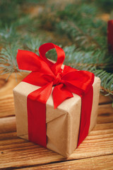 Christmas gifts with fir tree branches on wooden background