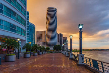 Cityscape of Guayaquil city at sunset with a view over the Malecon 2000 waterfront, the Guayas river and the point skyscraper after a thunderstorm, Ecuador. - obrazy, fototapety, plakaty