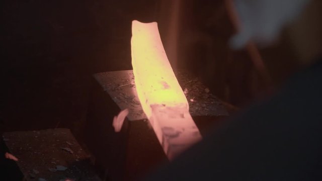 Blacksmith Forging Sword From Burning Steel With Automatic Hammer in Traditional Forge