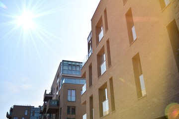 Modern apartment buildings on a sunny day with a blue sky. Facade of a modern apartment building.Glass surface with sunlight.