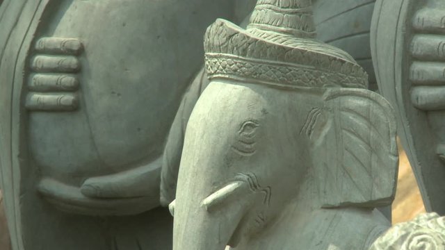 A daylight closeup shot of a carved stone elephant and other various symbolic statues in Buddhism that can be found in the village of San Tok, Cambodia.