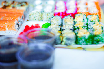 Sushi in a restaurant, Asian national seafood, a set of rolls of fish food with Chinese chopsticks.