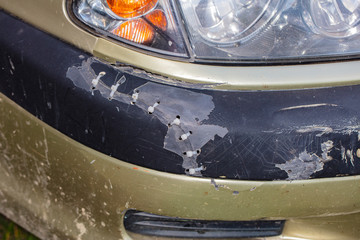 Obraz premium car bumper broken and connected with plastic threads