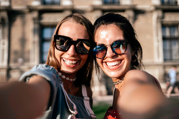Happy young women in sunglasses taking selfie