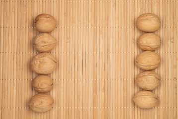 two stripes of walnuts on a wooden background