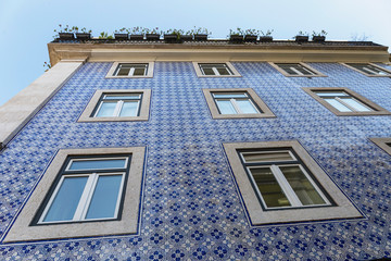 a fragment of the outer wall of a house in Lisbon decorated with ceramic tiles with a beautiful...
