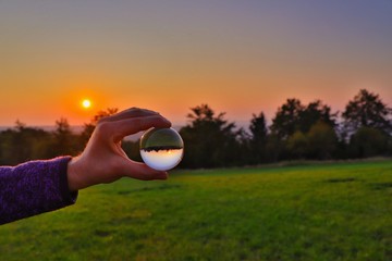 sonnenuntergang durch die glaskugel betrachten