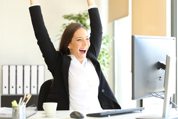 Excited businesswoman checking good news on computer