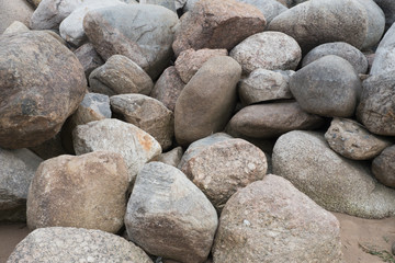 Retaining wall made of stones, boulders. Stone of volcanic rocks, granite, basalt, gabro. Bank protection on the sea beach. Protection of the coast from destruction by waves. Waterworks.