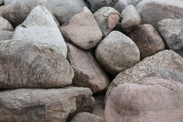 Retaining wall made of stones, boulders. Stone of volcanic rocks, granite, basalt, gabro. Bank protection on the sea beach. Protection of the coast from destruction by waves. Waterworks.