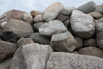 Retaining wall made of stones, boulders. Stone of volcanic rocks, granite, basalt, gabro. Bank protection on the sea beach. Protection of the coast from destruction by waves. Waterworks.