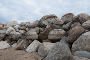 Retaining wall made of stones, boulders. Stone of volcanic rocks, granite, basalt, gabro. Bank protection on the sea beach. Protection of the coast from destruction by waves. Waterworks.