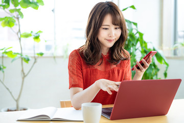 PCとスマホを使う女性