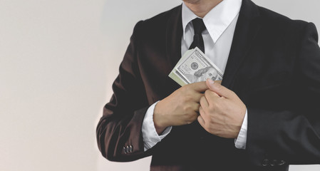businessman in black costume put or take out money in pocket, close up