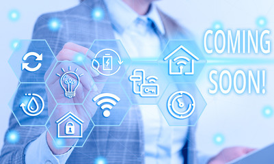 Writing note showing Coming Soon. Business concept for event or action that will happen after really short time Female human wear formal work suit presenting smart device