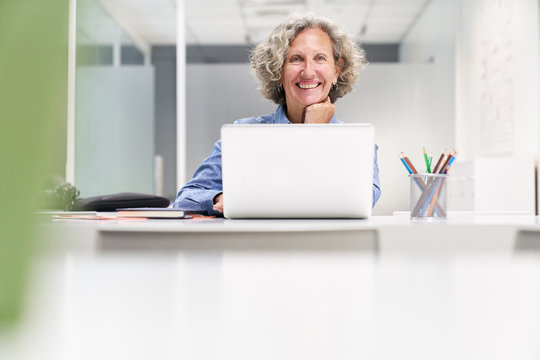 Glückliche Seniorin beim E-Learning am Computer