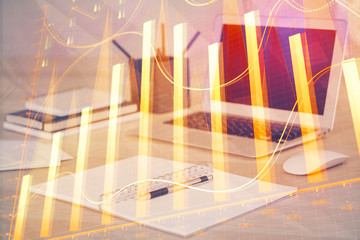 Stock market graph on background with desk and personal computer. Multi exposure. Concept of financial analysis.