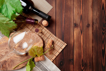Glass bottle of wine with corks on wooden table background - Image