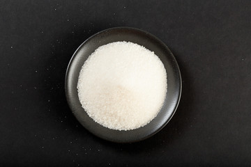 bowl of sugar  on black background