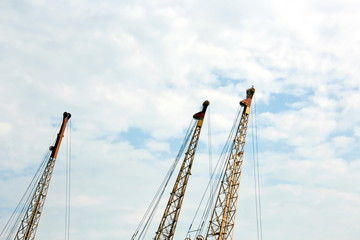 Cranes and masts against the blue sky.